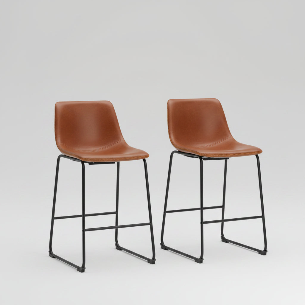 Two brown leather bar stools in front of a modern kitchen counter.