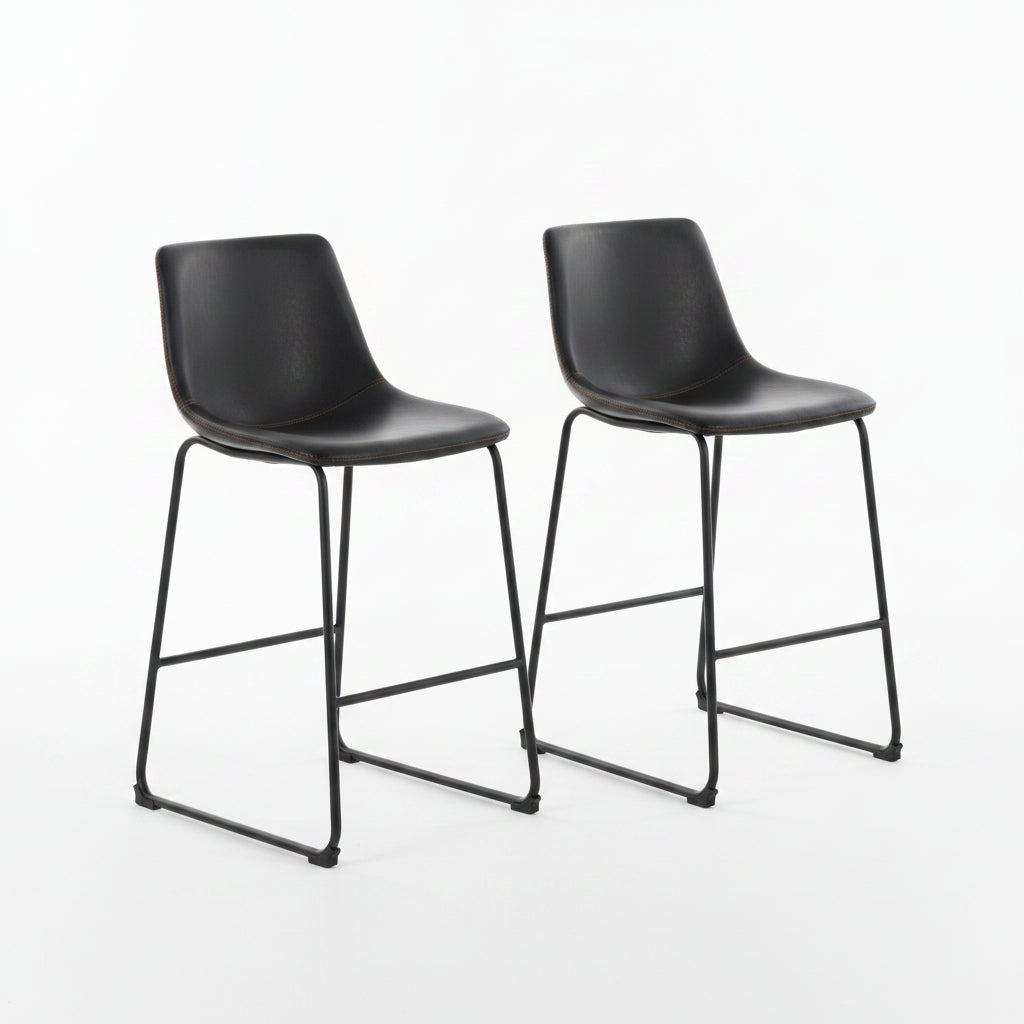 Two black bar stools in a modern kitchen setting with a wooden counter and decorative elements.