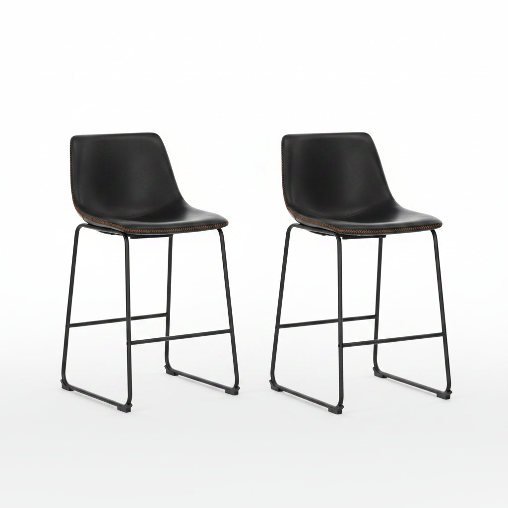 Two black bar stools in front of a modern kitchen counter.