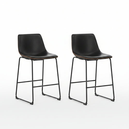 Two black bar stools in front of a modern kitchen counter.
